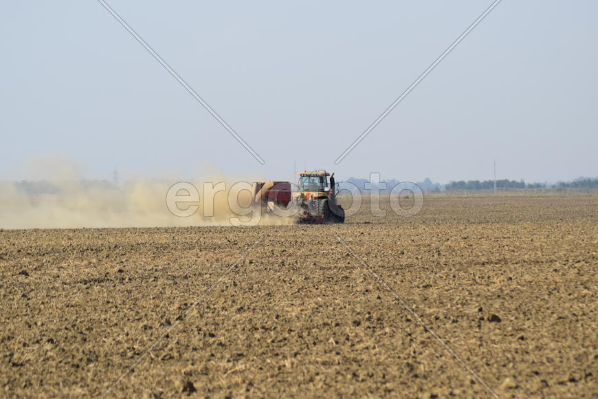 Russia, Temryuk - 19 July 2015: Tractor rides on the field and makes the fertilizer into the soil. C