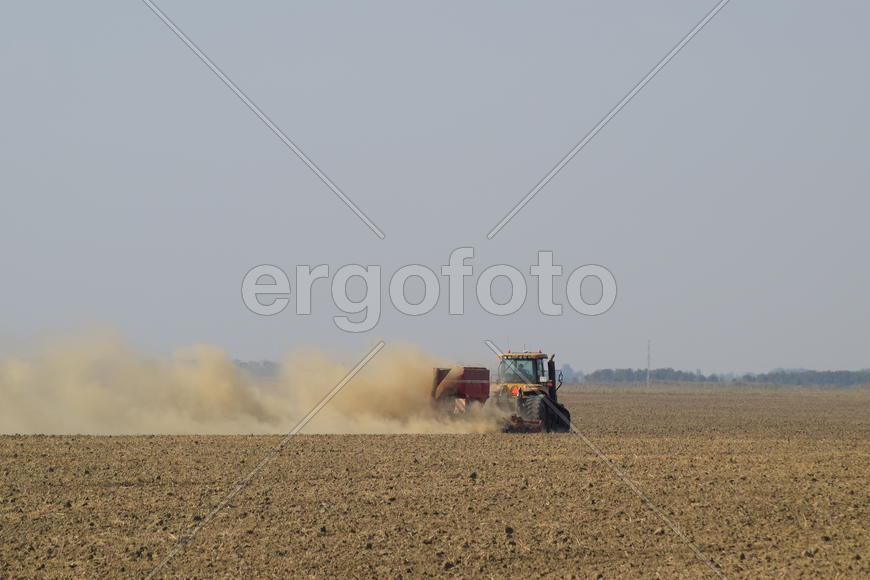 Russia, Temryuk - 19 July 2015: Tractor rides on the field and makes the fertilizer into the soil. C