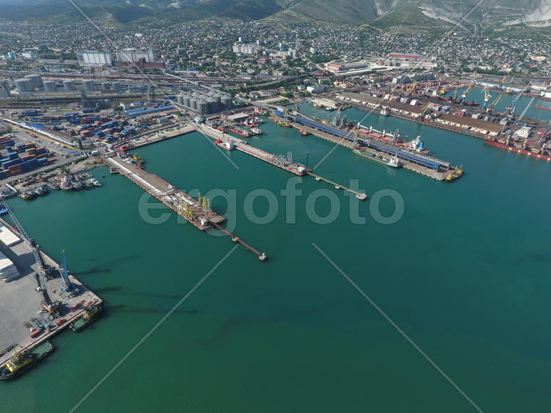 Industrial seaport, top view. Port cranes and cargo ships and barges. Loading and shipment of cargo 