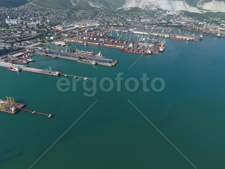 Industrial seaport, top view. Port cranes and cargo ships and barges. Loading and shipment of cargo 