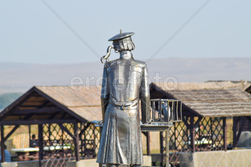 Статуя меховщика из металла с крысой в клетке. Металлическая статуя.