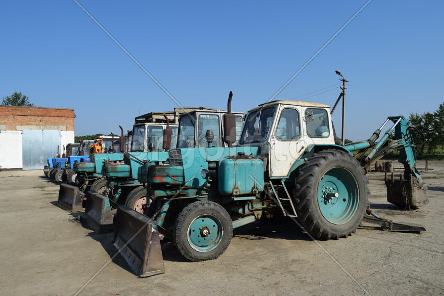 Tractor, standing in a row. Agricultural machinery. Parking of agricultural machinery.