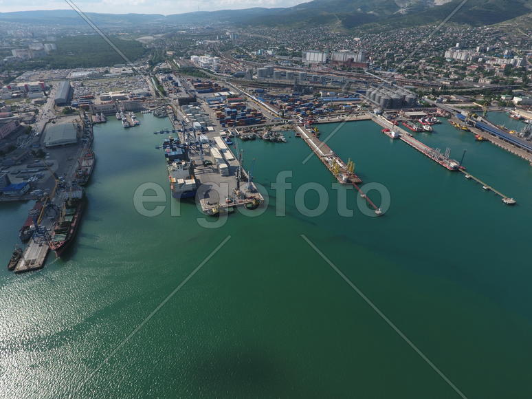 Industrial seaport, top view. Port cranes and cargo ships and barges. Loading and shipment of cargo 