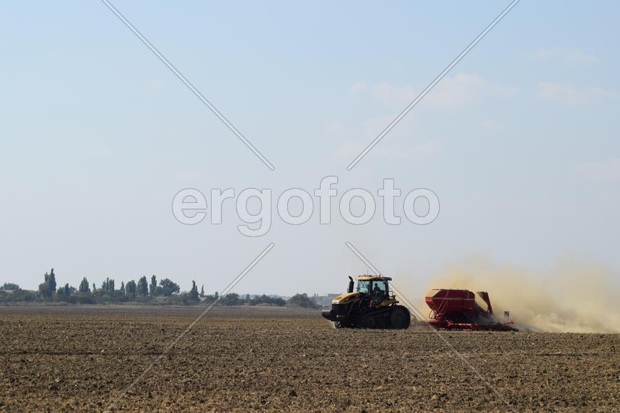 Russia, Temryuk - 19 July 2015: Tractor rides on the field and makes the fertilizer into the soil. C