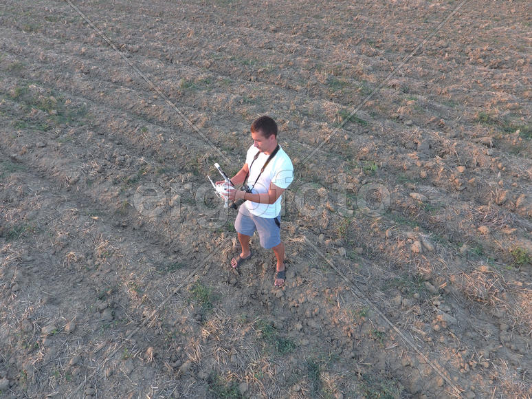 Мужчина держит в руках пульт дистанционного управления от квадрокоптера