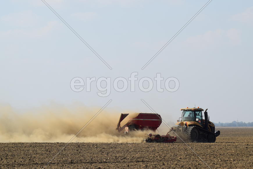 Russia, Temryuk - 19 July 2015: Tractor rides on the field and makes the fertilizer into the soil. C