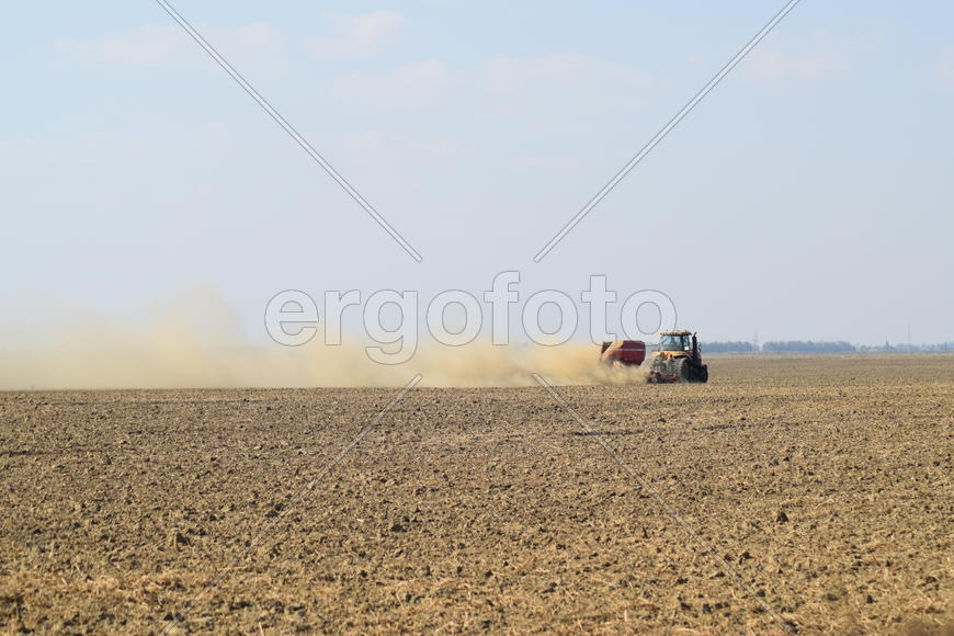 Russia, Temryuk - 19 July 2015: Tractor rides on the field and makes the fertilizer into the soil. C
