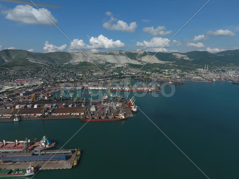 Industrial seaport, top view. Port cranes and cargo ships and barges. Loading and shipment of cargo 