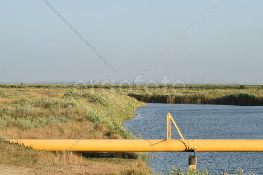The gas pipeline through the small river. Equipment of oil and gas crafts