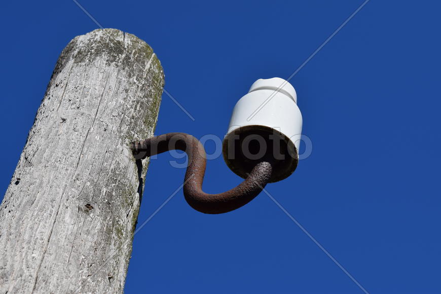 Wooden pole with an insulator. Transmission tower