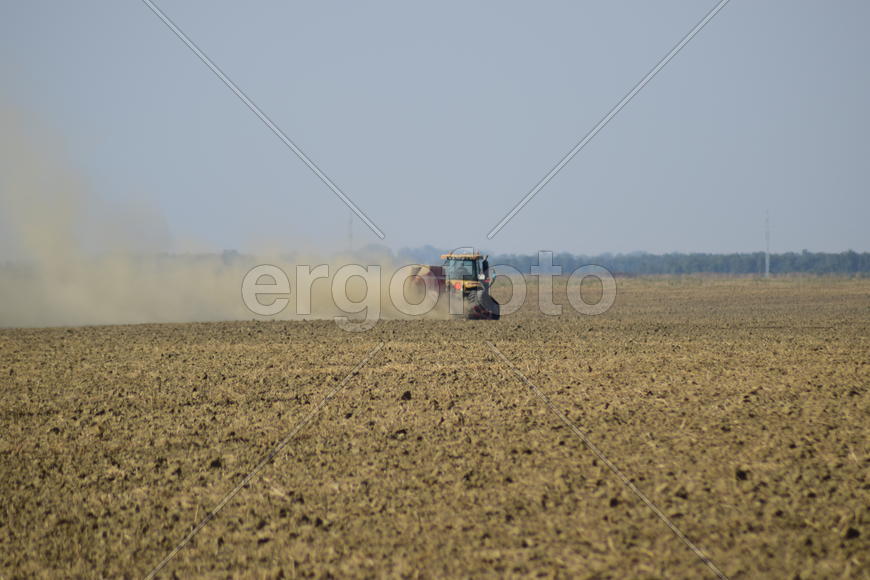 Russia, Temryuk - 19 July 2015: Tractor rides on the field and makes the fertilizer into the soil. C