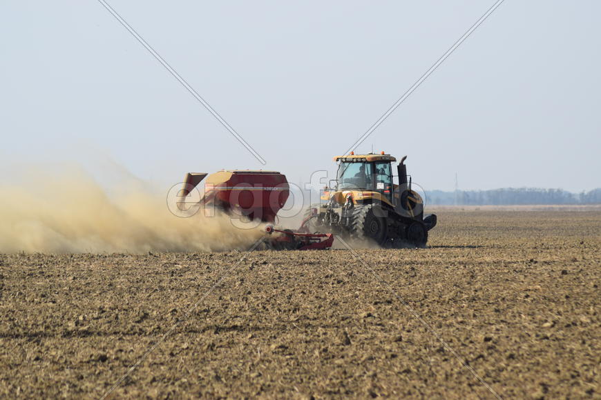 Russia, Temryuk - 19 July 2015: Tractor rides on the field and makes the fertilizer into the soil. C