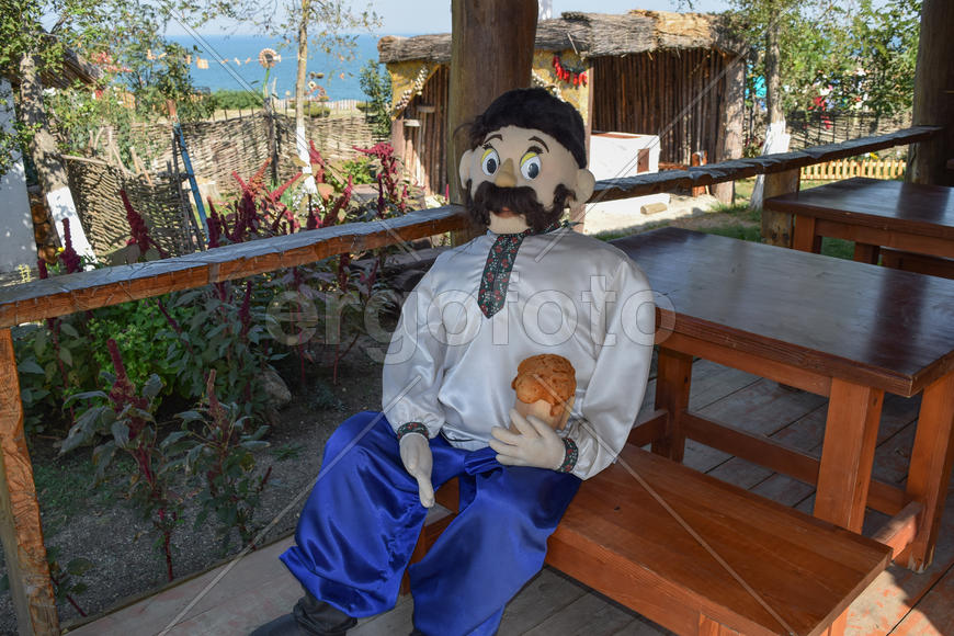 Кукла казака, сидящего на скамейке с пивом