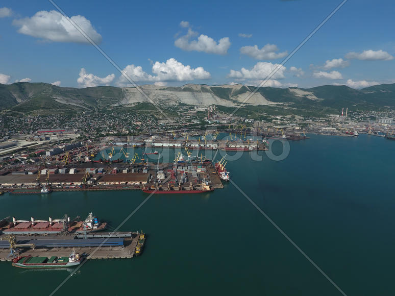 Industrial seaport, top view. Port cranes and cargo ships and barges. Loading and shipment of cargo 