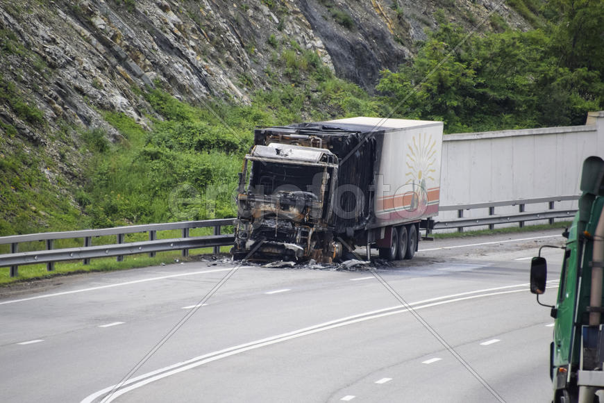 Сгоревший грузовик на шоссе. Автомобиль после пожара.