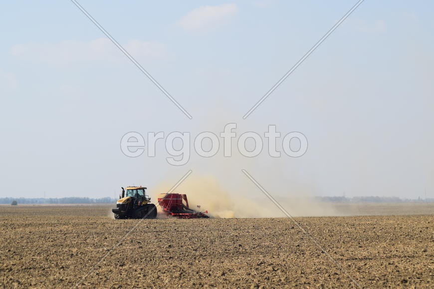 Russia, Temryuk - 19 July 2015: Tractor rides on the field and makes the fertilizer into the soil. C