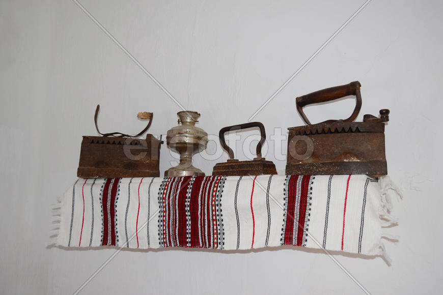 Древние утюги на деревянной полке 