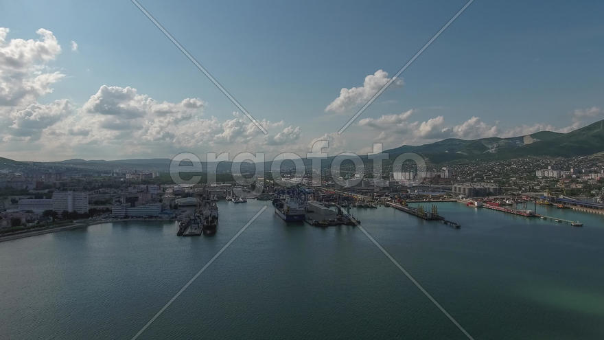 Industrial seaport, top view. Port cranes and cargo ships and barges. Loading and shipment of cargo 