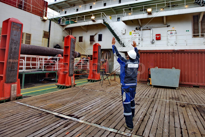 Работник показывает, где поставить груз.