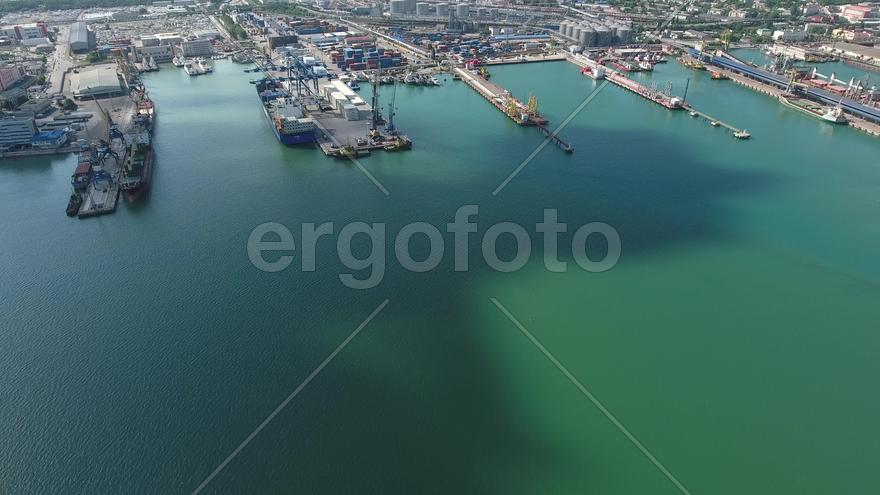 Industrial seaport, top view. Port cranes and cargo ships and barges. Loading and shipment of cargo 