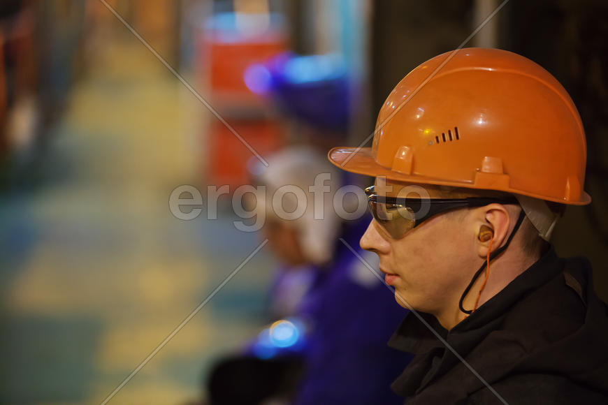 Рабочие слесари и сварщики в защитной одежде и шлеме. 