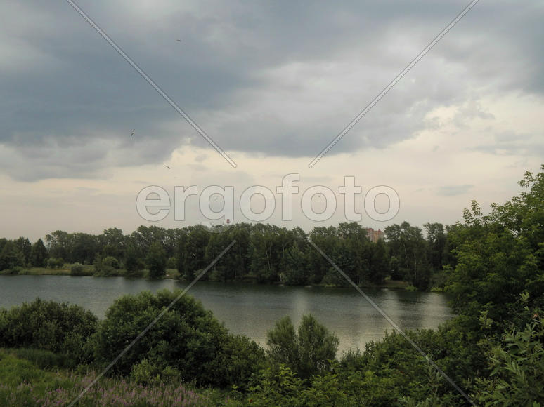 Черные грозовые тучи на озере