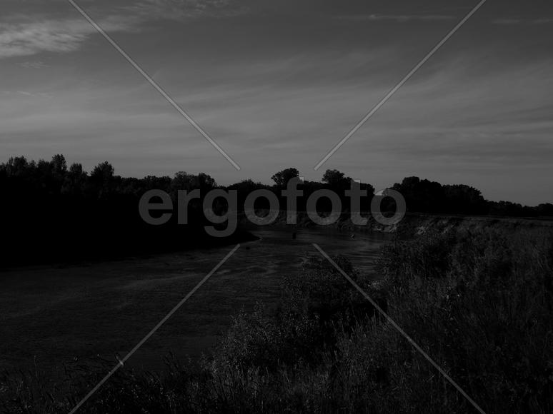 Bending river with banks on a black and white photo