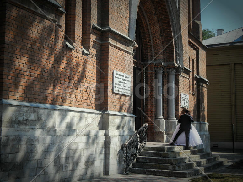 Молодожены на свадьбе стоят около музея