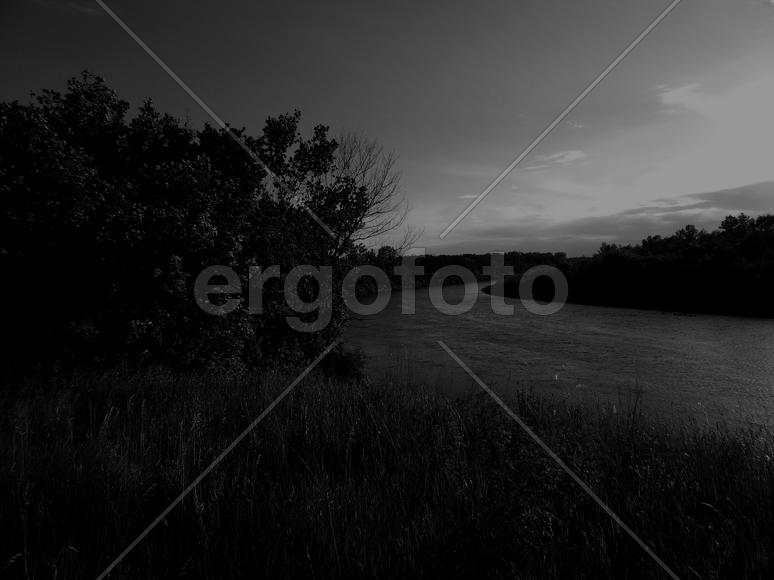 Bending river with banks on a black and white photo