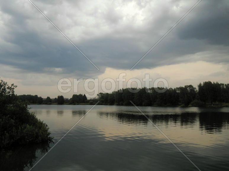 Черные грозовые тучи на озере