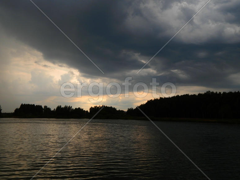 Черные грозовые тучи на озере