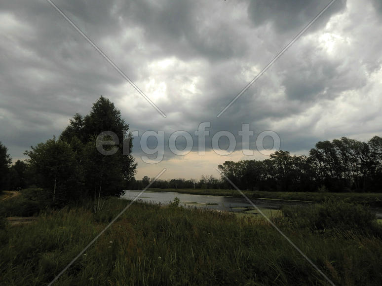 Черные грозовые тучи на озере