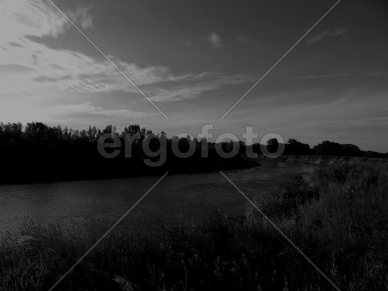 Bending river with banks on a black and white photo