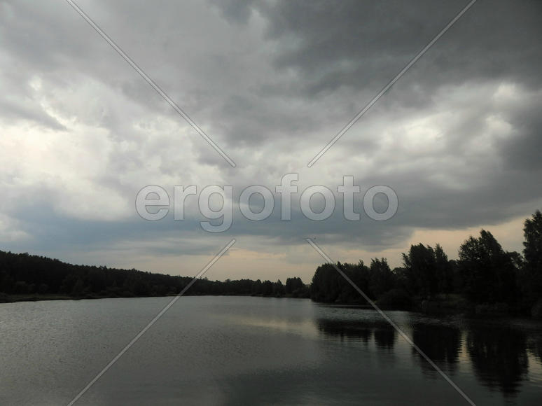 Черные грозовые тучи на озере