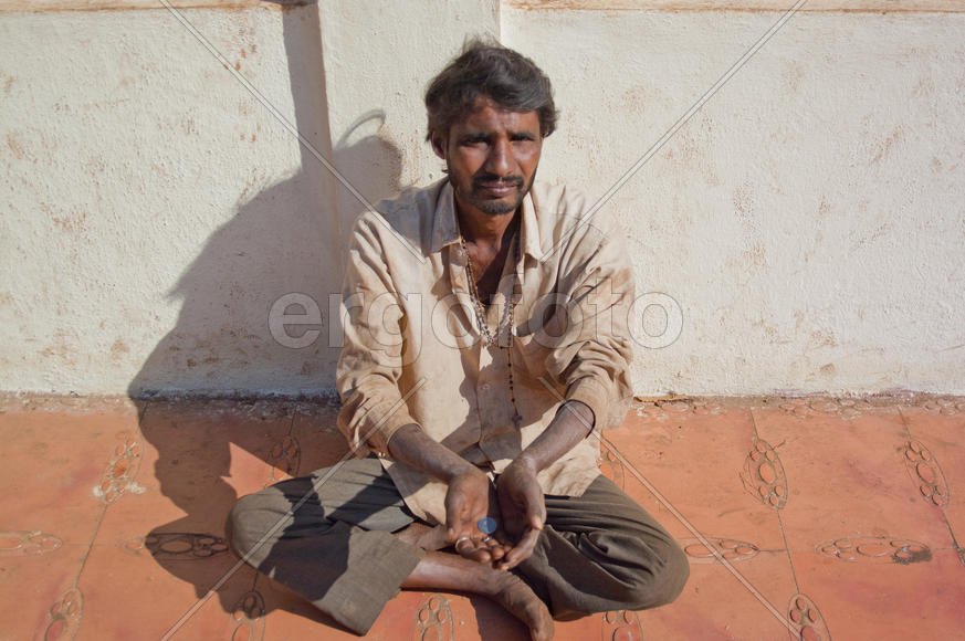 The beggar asks for alms in Old Goa near church