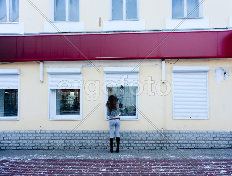 Girl closes the shutters outside the office