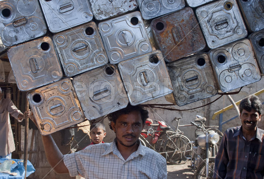 Man carries empty cans on his head in Mumbai