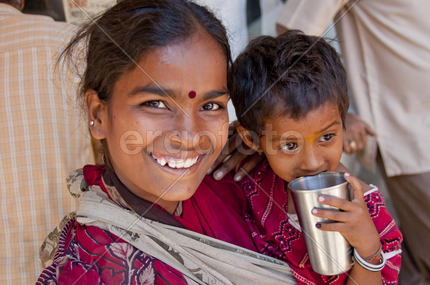 Girl with a child beggar on a street in Mumbai