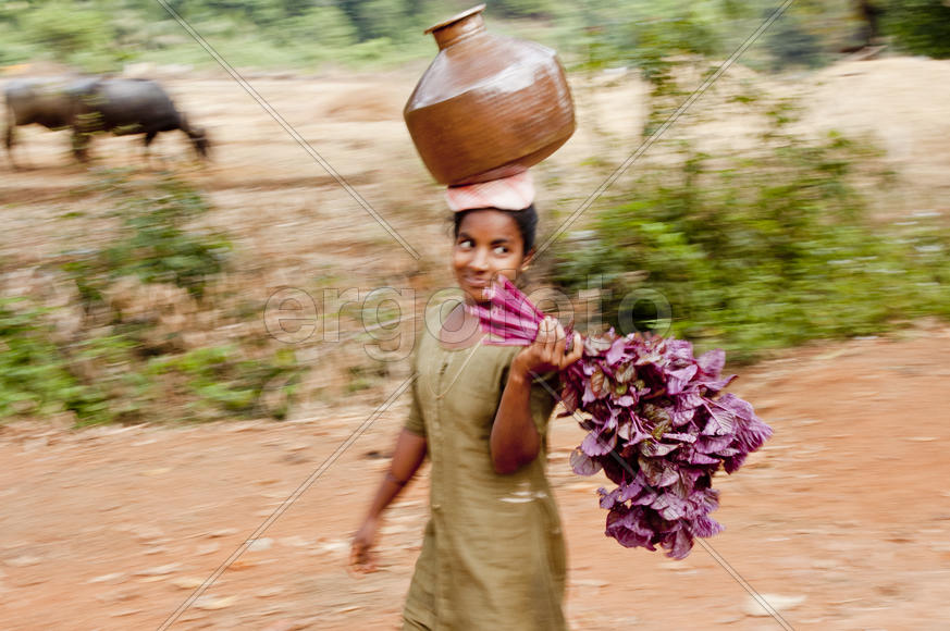 Woman carries water in a jar home