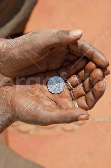 Hand holding a coin in a beggar one rupee