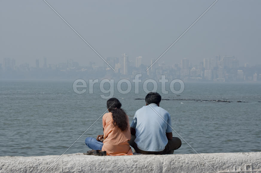 Young couple sitting on the promenade in Mumbai