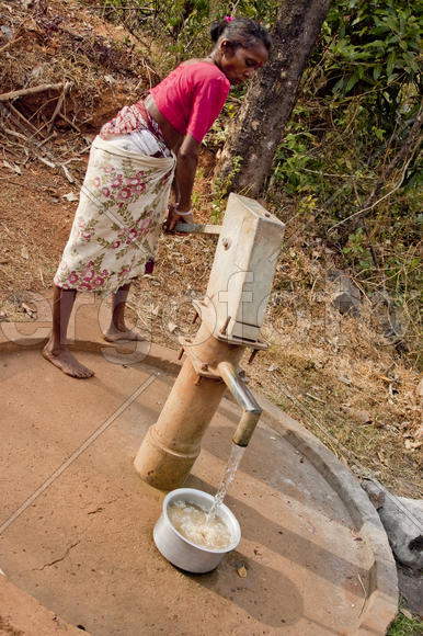 Woman collects water from the village column