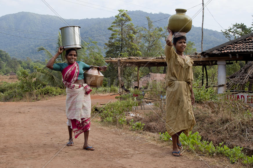 Woman carries water in a jar home
