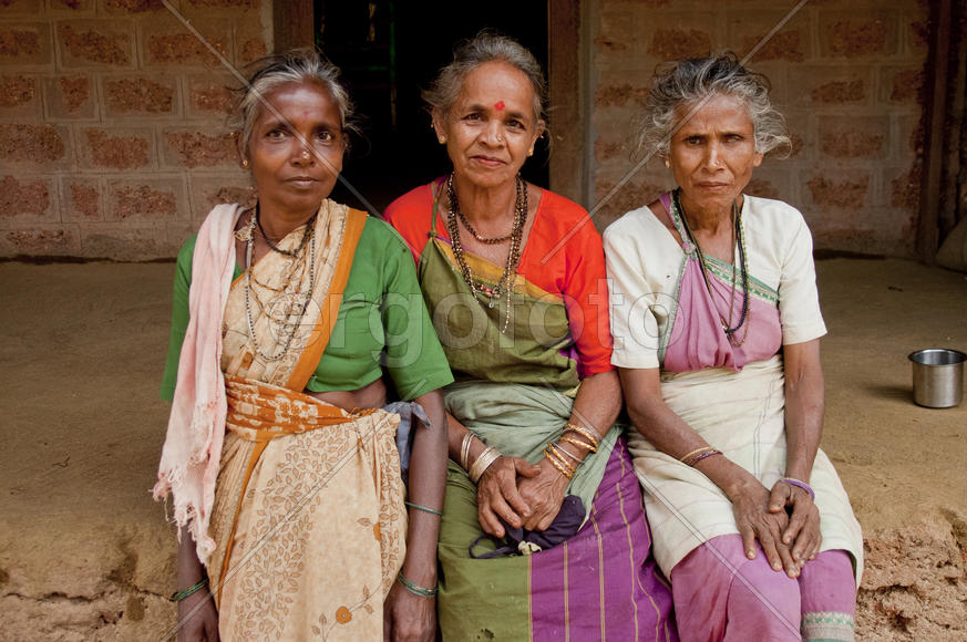 Three elderly women sitting on the bench in the Indian village