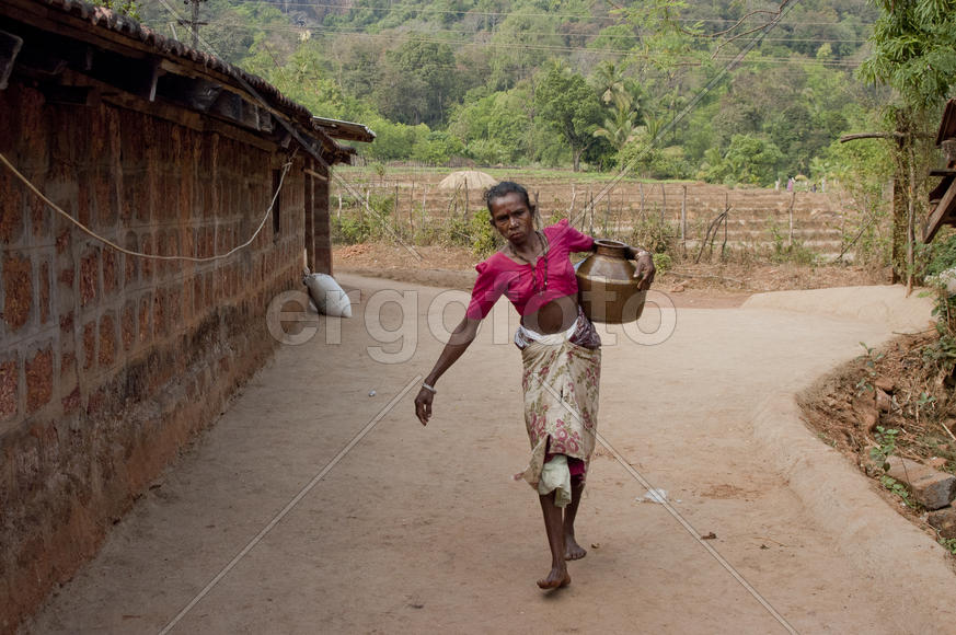 Woman carries water in a jar home