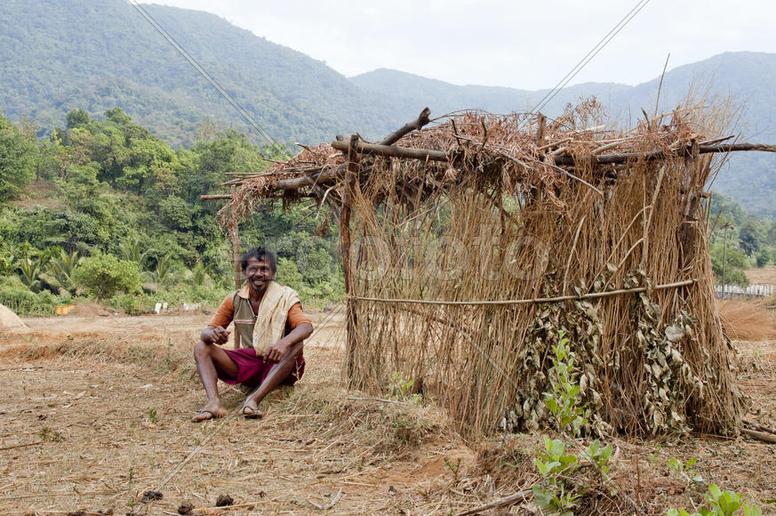 Rustic shepherd sitting in a field near the hut