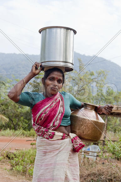 Woman carries water in a jar home