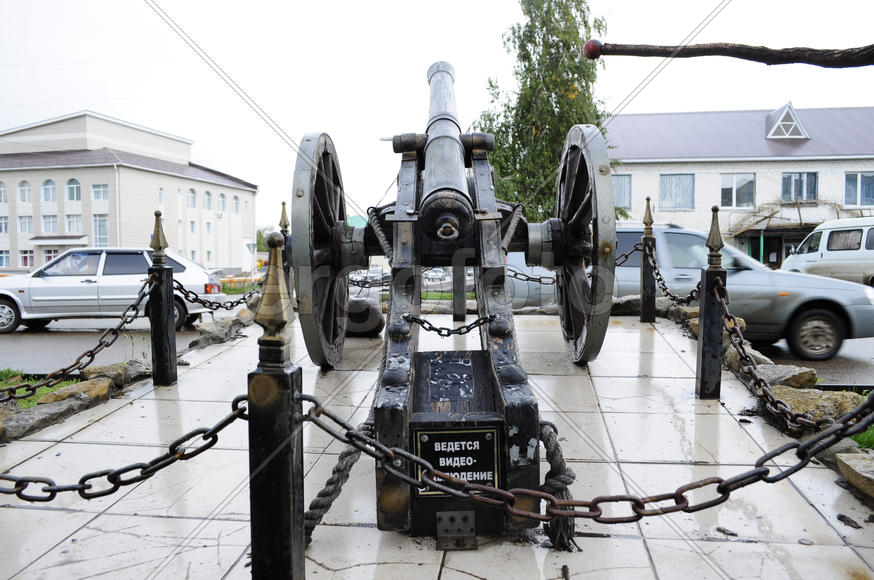 A monument of wooden gun on a city street
