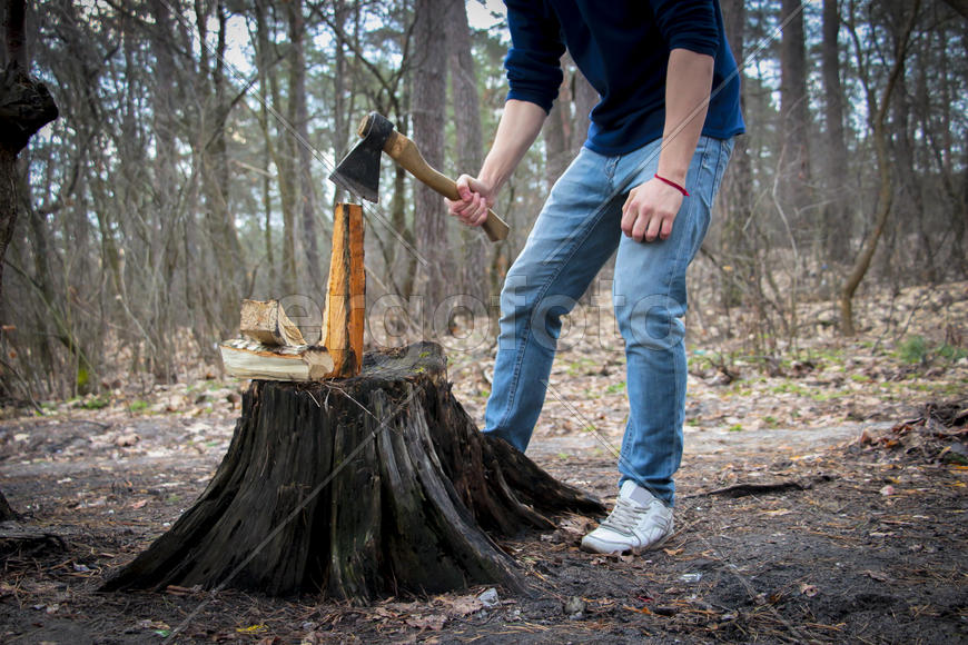 Человек с топором занимается колкой дров