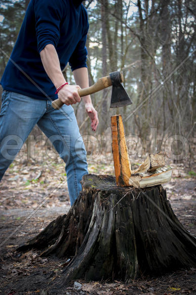 Человек с топором занимается колкой дров